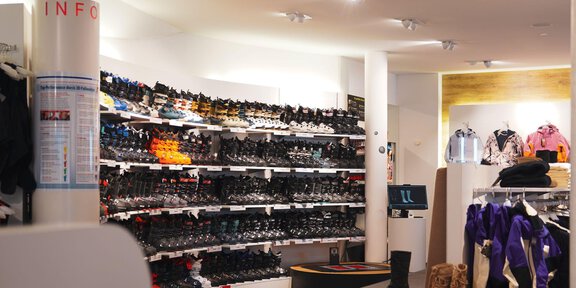 A sports store with shelves full of shoes in various colors. There are also some clothing items in the corner. - Intersport Glanzer Giggijochbahn | Shop 11 - Sölden