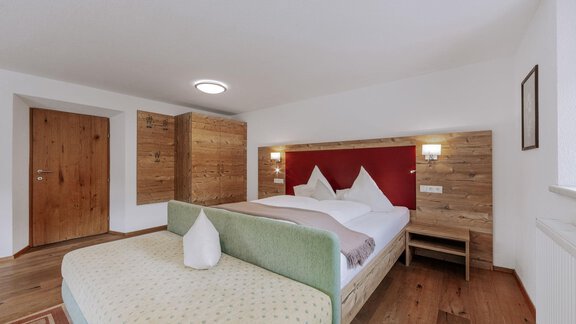 A modern bedroom with a cozy double bed and a bright wood decor. The room is well lit and offers a relaxed atmosphere. - Landhaus Waldesruh - Haiming
