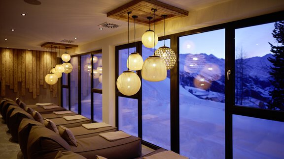 A cozy room with comfortable seating and large windows. Outside, you can see snow-covered mountains and a tranquil winter landscape. - Alpenhotel Laurin - Hochgurgl
