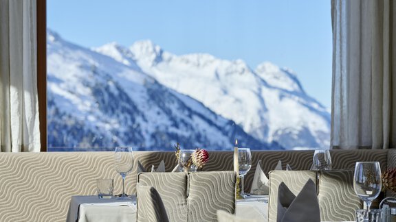 An elegant restaurant with a view of snow-covered mountains. The room is stylishly decorated and offers a cozy atmosphere. - Alpenhotel Laurin - Hochgurgl