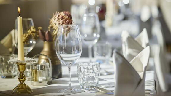 A beautifully set table with glasses, candles, and decorative elements. The atmosphere is elegant and inviting. - Alpenhotel Laurin - Hochgurgl