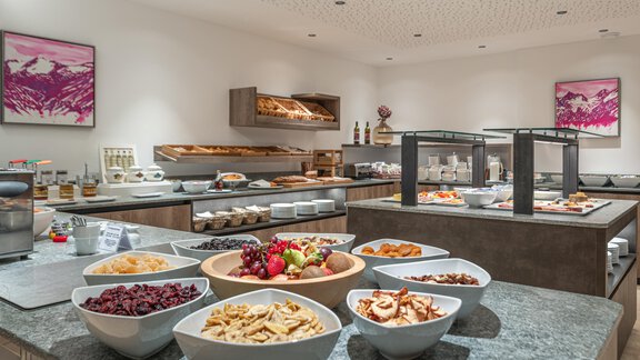 A beautifully decorated buffet with various snacks and fruits. In the background, fresh pastries and drinks are visible. - Hotel Angerer Alm - Hochgurgl