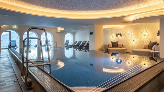 An elegant indoor pool with modern design and soft lighting.  
Relaxed loungers and a calm atmosphere invite you to linger. - Hotel Angerer Alm - Hochgurgl