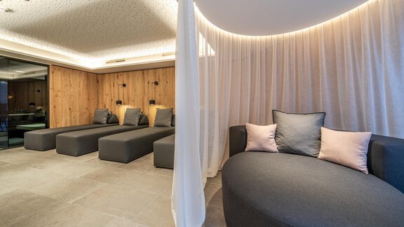 An elegant relaxation area with modern loungers and a cozy couch. Soft lighting and wood paneling create a calm atmosphere. - Hotel Angerer Alm - Hochgurgl