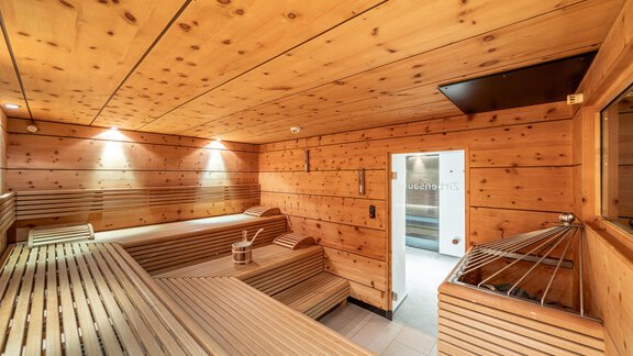 A modern sauna with wooden walls and benches. Gentle lighting creates a relaxing atmosphere. - Hotel Angerer Alm - Hochgurgl