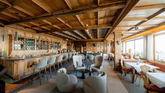 Ein gemütliches Restaurant mit Holzdekor und einer großen Bar. Große Fenster bieten einen schönen Blick auf die Umgebung. - TOP Hotel Hochgurgl - Hochgurgl