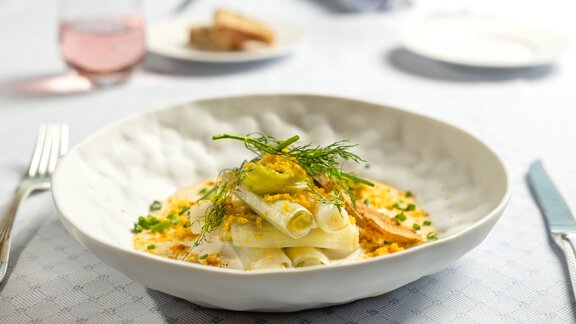 Ein stilvolles Gericht mit gefüllten Teigrollen auf einem Teller. Das Essen ist ansprechend mit Gemüse und Saucen garniert. - TOP Hotel Hochgurgl - Hochgurgl