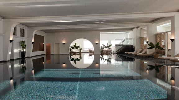 Ein eleganter Innenpool mit glattem Wasser und modernen Liegen. Die Atmosphäre ist entspannt und hell, mit Pflanzen, die den Raum schmücken. - TOP Hotel Hochgurgl - Hochgurgl