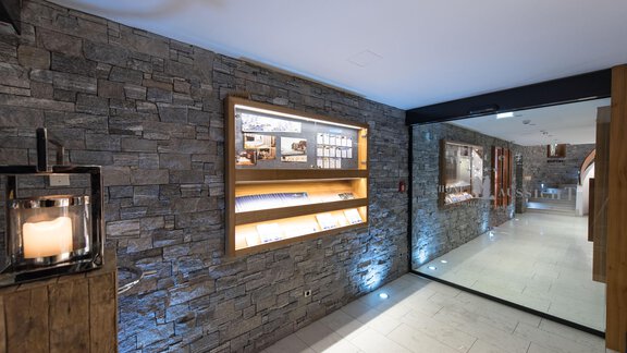 A modern hallway with bright stone walls and wooden shelves. The lighting creates an inviting atmosphere. - 4 * Superior Hotel Schöne Aussicht - Hochsölden