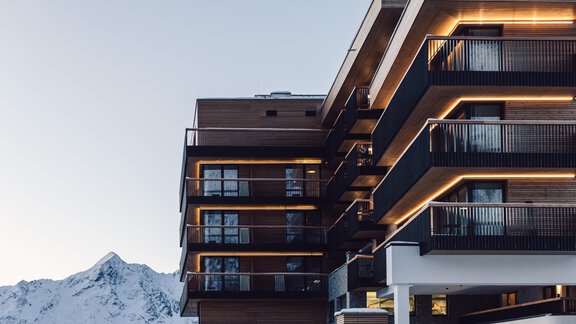 A modern hotel building with an elegant design. Snow-covered mountains can be seen in the background. - 4 * Superior Hotel Schöne Aussicht - Hochsölden