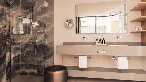 A modern bathroom with an elegant shower and a large mirror. The decor is kept simple, with a subtle color tone and minimalist accessories. - 4 * Superior Hotel Schöne Aussicht - Hochsölden