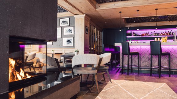 A stylish bar with a modern fireplace system. The lighting is soft and creates a cozy atmosphere. - 4 * Superior Hotel Schöne Aussicht - Hochsölden