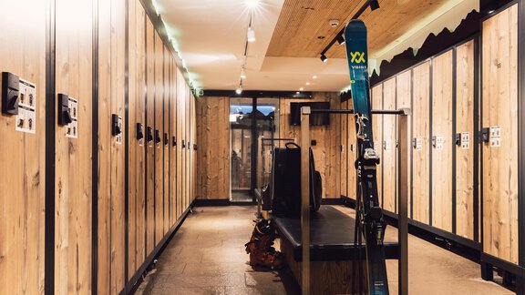 A modern ski room with wooden lockers and a ski sled. In the background, skis and equipment are visible. - 4 * Superior Hotel Schöne Aussicht - Hochsölden