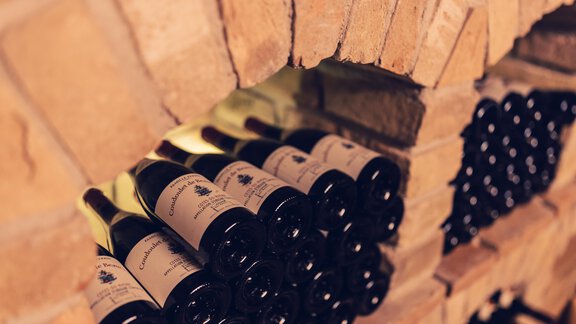 A wine cellar with several bottles of wine neatly stacked. The walls are made of bricks and create a cozy atmosphere. - 4 * Superior Hotel Schöne Aussicht - Hochsölden