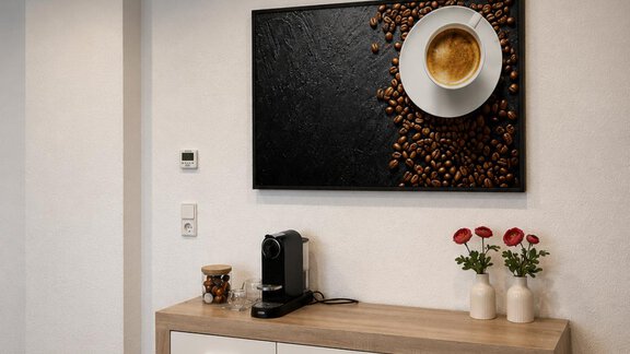 Eine moderne Küchenzeile mit einem eleganten Holzschrank. An der Wand hängt ein Kunstwerk mit einer Kaffeetasse und Kaffeebohnen. - ONO Apartments - Huben
