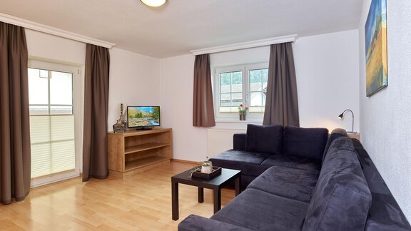 Wohnzimmer mit Eckcouch und Zugang zum Balkon - Andys Apartment - Längenfeld
