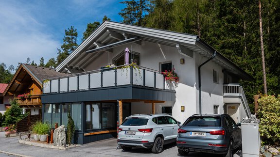 A modern house with a balcony and several cars in front of it. Surrounded by trees and beautiful nature. - Apart Conny - Längenfeld
