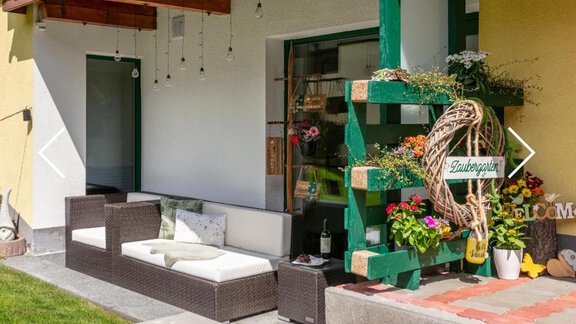 A cozy terrace with modern furniture and colorful flowers. The green wall shelf gives the space an inviting character. - Apartment DoLa - Längenfeld