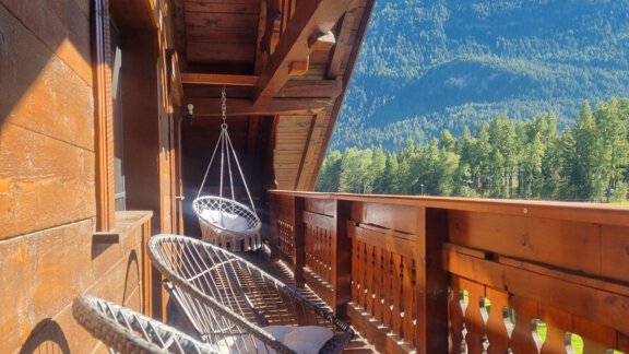 Ein gemütlicher Balkon mit hängenden Sesseln und Aussicht auf die Berge. Die warmen Holztöne schaffen eine einladende Atmosphäre. - Bauernhaus Auer - Längenfeld