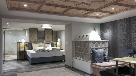 Ein modernes Zimmer mit einem gemütlichen Bett und stilvollem Holzdekor. Der Raum ist gut beleuchtet und hat einen einladenden, eleganten Look. - Hotel Stern - Längenfeld