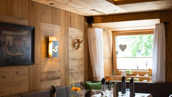 Ein gemütliches Restaurant mit warmem Holzinterieur. Der Tisch ist elegant gedeckt und bietet Platz für mehrere Gäste. - Hotel Stern - Längenfeld