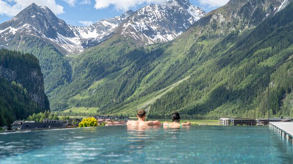 Ein entspannendes Schwimmbad mit Blick auf beeindruckende Berge. Die grüne Landschaft und der blaue Himmel sorgen für eine idyllische Atmosphäre. - Hotel Stern - Längenfeld