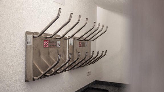A wall with several stainless steel hooks for hanging items. The room feels simple and functional. - MYALPS Himmelreich - Längenfeld