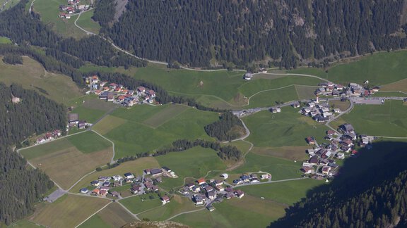 A picturesque landscape with small villages and green meadows in the mountains. The sky is clear and nature appears calm and inviting. - Appartement Lea - Niederthai