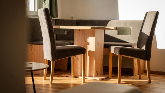 Ein gemütlicher Essbereich mit einem holzfarbenen Tisch und Stühlen. Das Licht fällt sanft durch das Fenster und beleuchtet den Raum. - Sonnenhof - Niederthai