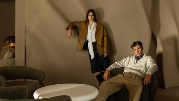 Two models are posing in a modern interior. They are wearing stylish autumn fashion against a neutral wall color. - Austria Gourmet & Wine Hotel - Obergurgl 
