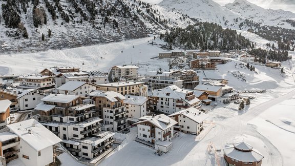 A snowy mountain landscape with residential buildings in a quiet valley. The surroundings are encircled by snow-covered mountains and exude a peaceful, wintry atmosphere. - Chalet Cecilia by MYALPS - Obergurgl 
