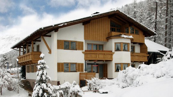 A charming house in the winter snow, surrounded by white forests. The sky is blue with a few clouds. - Ferienwohnung Poschacherhof - Obergurgl 