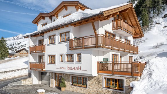 A beautiful chalet in the snow with wooden balconies and a clear blue sky. Perfect for a winter holiday in the mountains. - Haus Elisabeth - Obergurgl 
