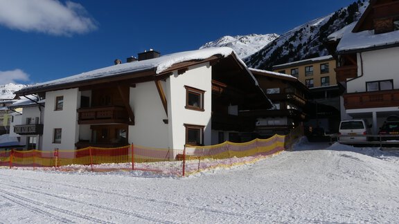 An old, charming house in the snow with a light blue sky. The surroundings are surrounded by mountains and radiate a winter atmosphere. - Haus Mennecke - Obergurgl 