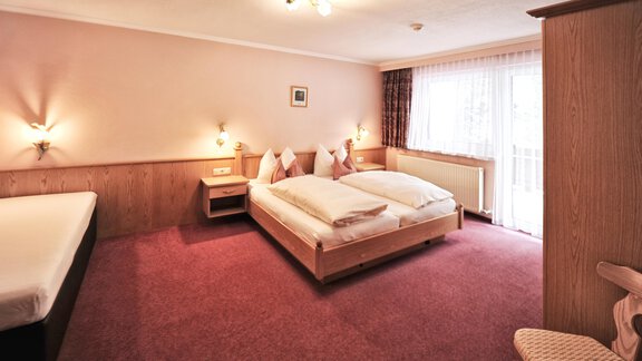 A bright room with two single beds and an additional bed. The cozy decor creates an inviting atmosphere. - Haus Timmelseck - Obergurgl 