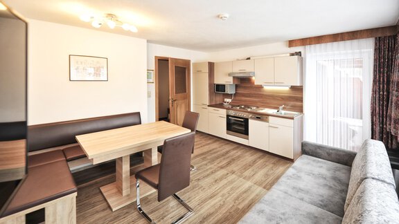 A modern apartment with an open kitchen and dining area. The space is brightly and friendly furnished. - Haus Timmelseck - Obergurgl 