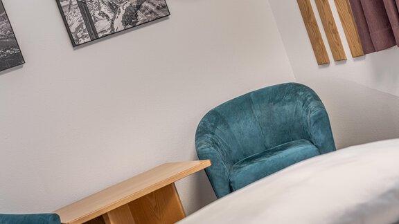 A cozy room with two turquoise armchairs and a wooden table. Black and white photos hang on the wall. - Haus Timmelseck - Obergurgl 