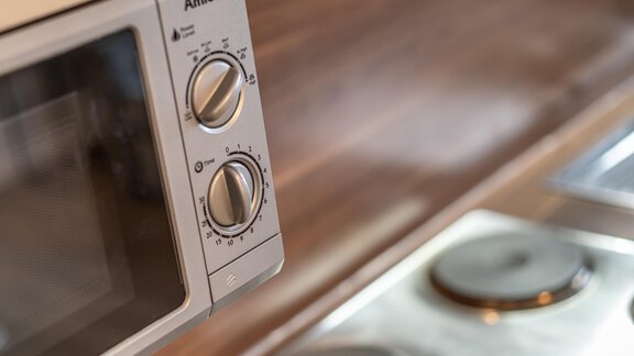 A modern microwave with rotary knobs. It is located in a modern kitchen with a sleek countertop. - Haus Timmelseck - Obergurgl 