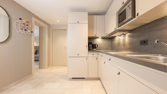 A modern kitchen with bright cabinets and a countertop. There is a microwave and a coffee machine, as well as plenty of space for cooking. - Haus Verwall Appartements - Obergurgl 