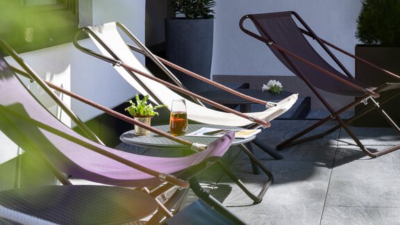 Relaxed loungers on a terrace with plants and a drink. A quiet place to relax and enjoy. - Haus Verwall Appartements - Obergurgl 