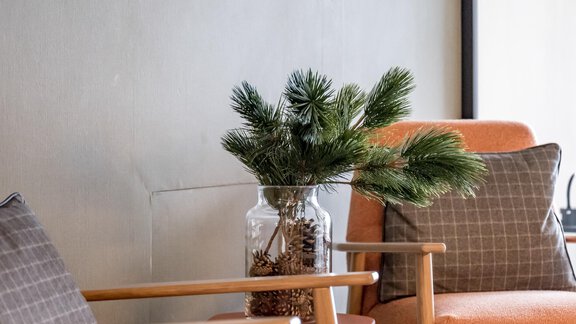 Two comfortable armchairs in orange with gray cushions are in a modern room. A glass with a plant and a small table complete the decor. - The Moss - Your unique hideaway - Obergurgl 