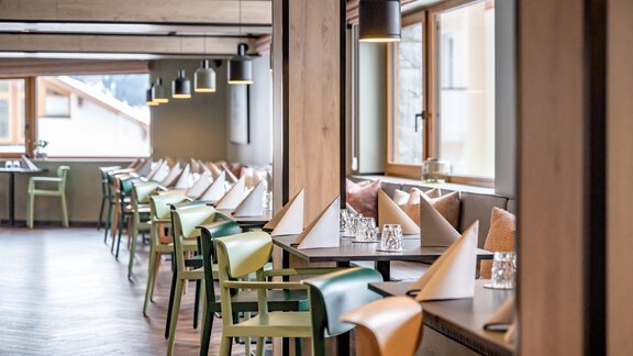 A modern restaurant with wood decor and a cozy atmosphere. Tables are carefully set and there are many windows that provide plenty of natural light. - The Moss - Your unique hideaway - Obergurgl 