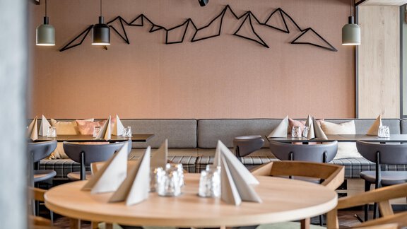 A modern restaurant with stylish interior and mountain-themed wall decor. The tables are lovingly set and invite guests to linger. - The Moss - Your unique hideaway - Obergurgl 