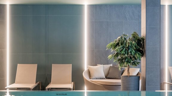 An elegant wellness area with loungers and a cozy seating area. The soft lighting and a plant create a relaxed atmosphere. - The Moss - Your unique hideaway - Obergurgl 