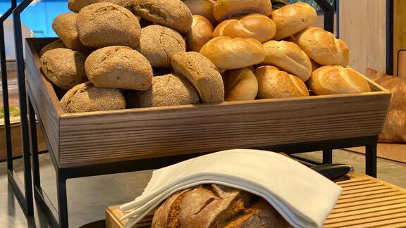 A basket with freshly baked bread and rolls. Different types of bread are neatly stacked and ready to serve. - The Moss - Your unique hideaway - Obergurgl 