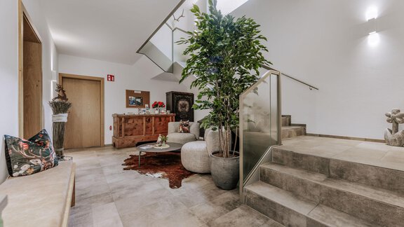 Ein einladender Wohnbereich mit modernen Möbeln und einer schönen Pflanze. Die Treppe führt in einen oberen Bereich des Raumes. - Apartment Waldesruh - Ochsengarten