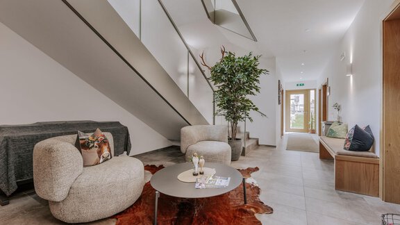 Ein moderner Flur mit einem gemütlichen Sitzbereich. Die Wände sind hell und es gibt viel Licht, das den Raum freundlich und einladend macht. - Apartment Waldesruh - Ochsengarten
