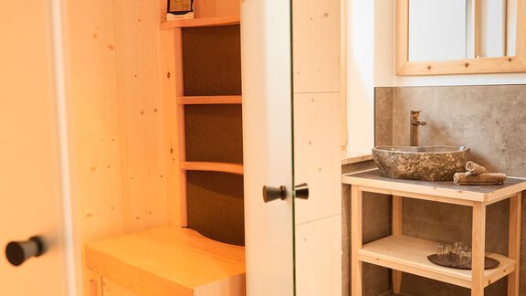 Eine moderne Sauna aus hellem Holz mit einer entspannenden Atmosphäre. Neben der Sauna befindet sich ein stilvoller Waschtisch aus Naturstein. - Gasthof Walderhof - Ochsengarten