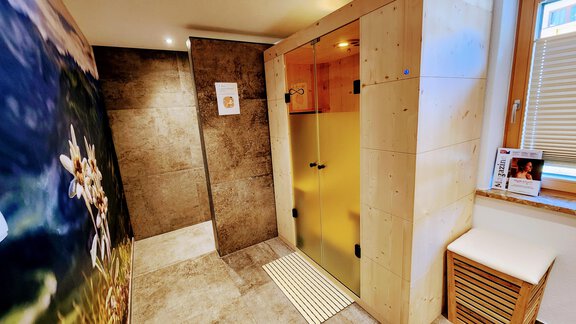 Ein moderner Wellnessbereich mit einer Glasdusche und eleganten Natursteinelementen. Die Wände sind dekoriert und schaffen eine entspannende Atmosphäre. - Gasthof Walderhof - Ochsengarten
