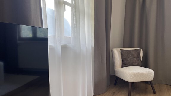 Im Wohnzimmer befindet sich eine Couch, Sessel und TV. - Fina - Garten Maisonette - Oetz